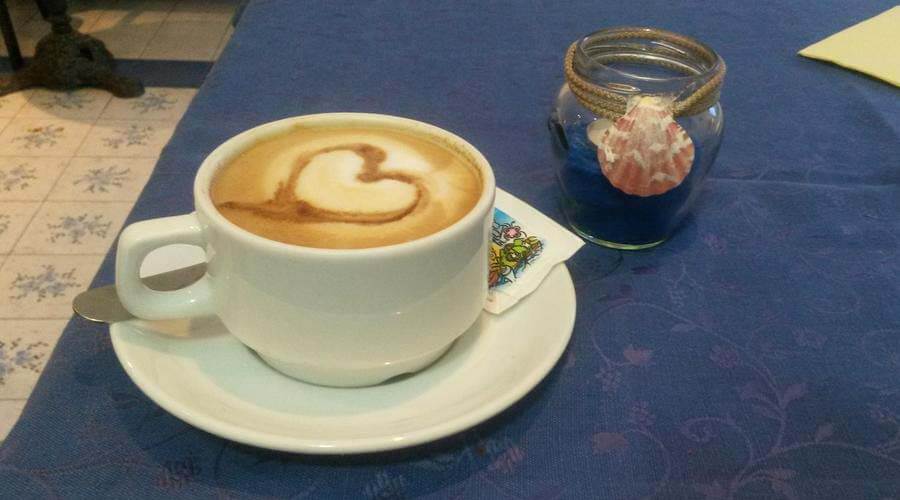 foto di una tazza di cappuccino sul tavolo della colazione dell'hotel costa citara di forio